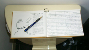 Photo: Guest book with pen on toilet tank.